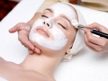 Woman receiving facial mask at beauty salon